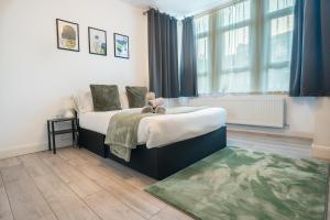 a bedroom with a bed and a large window at Modern 3 Bed Flat - 3 En-Suites - Parking - near Wembley in Edgware