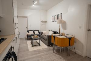 a living room with a couch and a table at Modern 3 Bed Flat - 3 En-Suites - Parking - near Wembley in Edgware