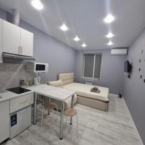 a kitchen with a table and a bed in a room at Byrabau Tauwer in Shchūchīnsk