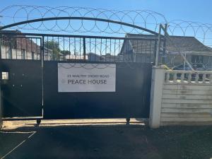 a gate with a sign that reads a water stop and a peace house at Peace House in Pietermaritzburg