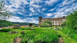 a large building with a grassy field in front of it at Duplex de l'abbaye in Pébrac