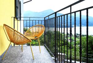 two chairs on a balcony with a view of the ocean at Sunny View Lake Como Apartment- Trilo in Consiglio di Rumo +3 photos
