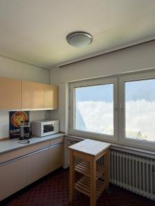 a kitchen with a table and a microwave and two windows at Schöne Aussicht in Idar-Oberstein +6 photos