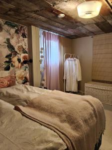 a bedroom with a bed and a floral wall at Tyynynpaikka in Tampere