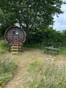 a bench and a picnic table in a field at Vardo gypsy wagon in Berwick Saint John +4 photos