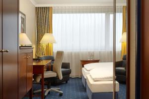 a hotel room with a bed and a desk at Sunday Hotel Kassel in Kassel