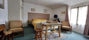 a bedroom with a bed and a table and chairs at La Fischaumière in Soleilhas +15 photos