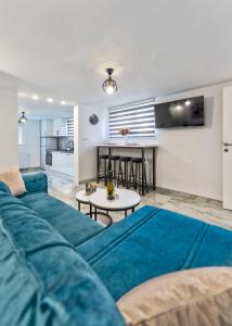 a living room with a blue couch and a table at Evergreen Escape Apartment in Užice
