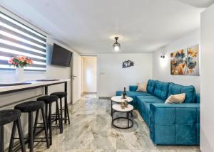 a living room with a blue couch and a bar at Evergreen Escape Apartment in Užice +12 photos