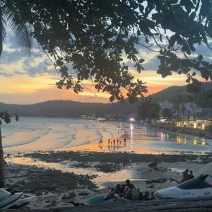 a group of people on a beach at sunset at Nhà nghỉ Vân Hùng in Mui Ne