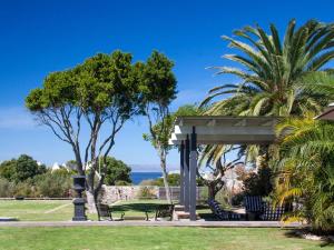 a park with a bench and palm trees at The Gregoire Boutique Villa in Hermanus