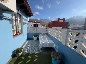 a balcony with a bench on a blue building at Casa Nazario Duplex in Los Llanos de Aridane