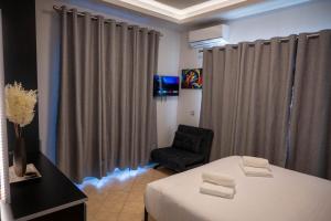a room with a bed and a chair and curtains at VILLA Konstantinos in Agios Georgios