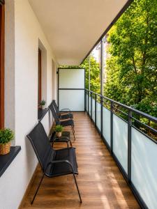 a balcony with chairs and a table on a building at Sportova Elegance Apartment in Płock