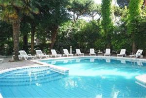 a large swimming pool with lounge chairs at Hotel New York in Cervia