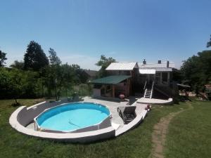 a large swimming pool in a yard next to a house at Apartman LAVANDA in Šumarak