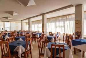 a dining room with blue tables and chairs at Hotel New York in Cervia