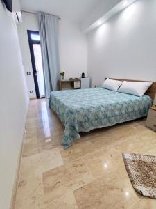a bedroom with a bed in a white room at Casa vacanze Poma in Custonaci