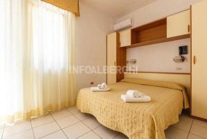a bedroom with a bed with towels on it at Hotel New York in Cervia