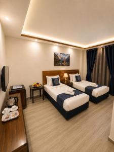 a hotel room with two beds and a television at Sky Royal Hotel in Petra