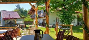 a patio with tables and chairs in front of a house at Casa Verde in Vrîncioaia Negrileşti