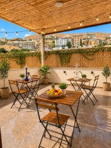 a patio with tables and chairs with a view of a city at Sky Royal Hotel in Petra