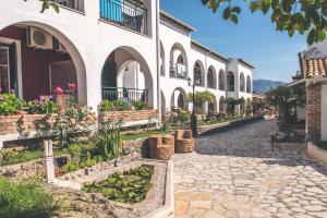 a cobblestone street in front of a building at Iliada Beach Hotel in Gouvia