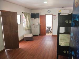 a living room with a wooden floor and a bedroom at El Hostal By Pochet in San Andrés