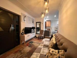 a living room with a couch and a television at Kay's Guest House in Kraaifontein