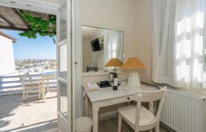 a room with a desk with a view of a balcony at Petali Village Hotel in Apollonia