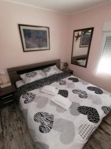 a bedroom with a bed with a black and white comforter at Apartman LAVANDA in Šumarak +43 photos