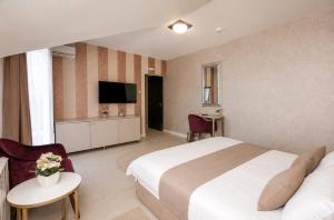 a hotel room with a bed and a television at Hotel Bajadera Lux in Belgrade