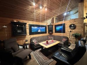a living room with couches and a table and tv at Lakefront Cabin on Vråvatn in Kviteseid
