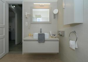 a bathroom with a sink and a mirror at Petali Village Hotel in Apollonia +55 photos