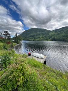 a boat sitting on the side of a lake at Lakefront Cabin on Vråvatn in Kviteseid