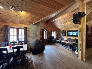 a living room with a table and a fireplace at Lakefront Cabin on Vråvatn in Kviteseid