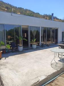 a building with a patio with plants and a table at la casa del cerro in Olmué