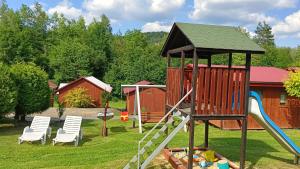 a playground with a slide and two chairs at Noclegi U Renaty Solina in Solina
