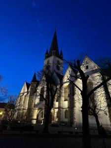 a white church with a clock tower at night at Insieme Studio - Small Square in Sibiu