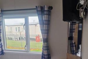 a window with a view of a house at 3 Bed - Sleeps 8 - Family & Pet Friendly in Skegness