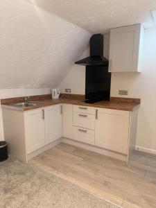 a kitchen with white cabinets and a sink at Star Studios in Southampton