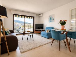 a living room with a couch and a table at La Marina Cannes Suites in Mandelieu-La Napoule