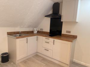 a small kitchen with white cabinets and a sink at Star Studios in Southampton