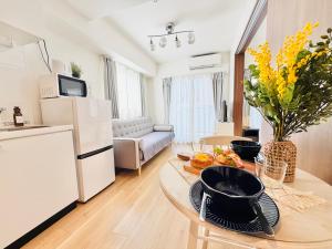 a living room with a kitchen and a table with a bowl of fruit at u-heim Osaka Tengachaya in Osaka +30 photos