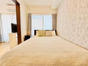 a bedroom with a large bed with a large window at u-heim Osaka Tengachaya in Osaka
