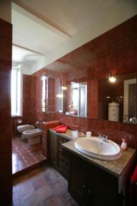 een grote badkamer met een wastafel en 2 toiletten bij Agriturismo Antica Golena in Guastalla