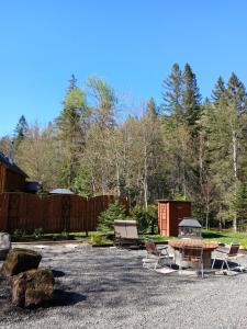 a patio with a table and chairs in a yard at Le Iris in Saint-Alexis-des-Monts