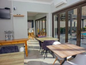a room with two tables and chairs and windows at 5@Partridge Guesthouse in Newcastle
