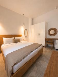 a bedroom with a large bed and a table at MykoNest in Agios Stefanos
