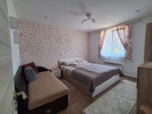 a small bedroom with a bed and a window at Къща за гости ИЛТА in Novo Delchevo +5 photos